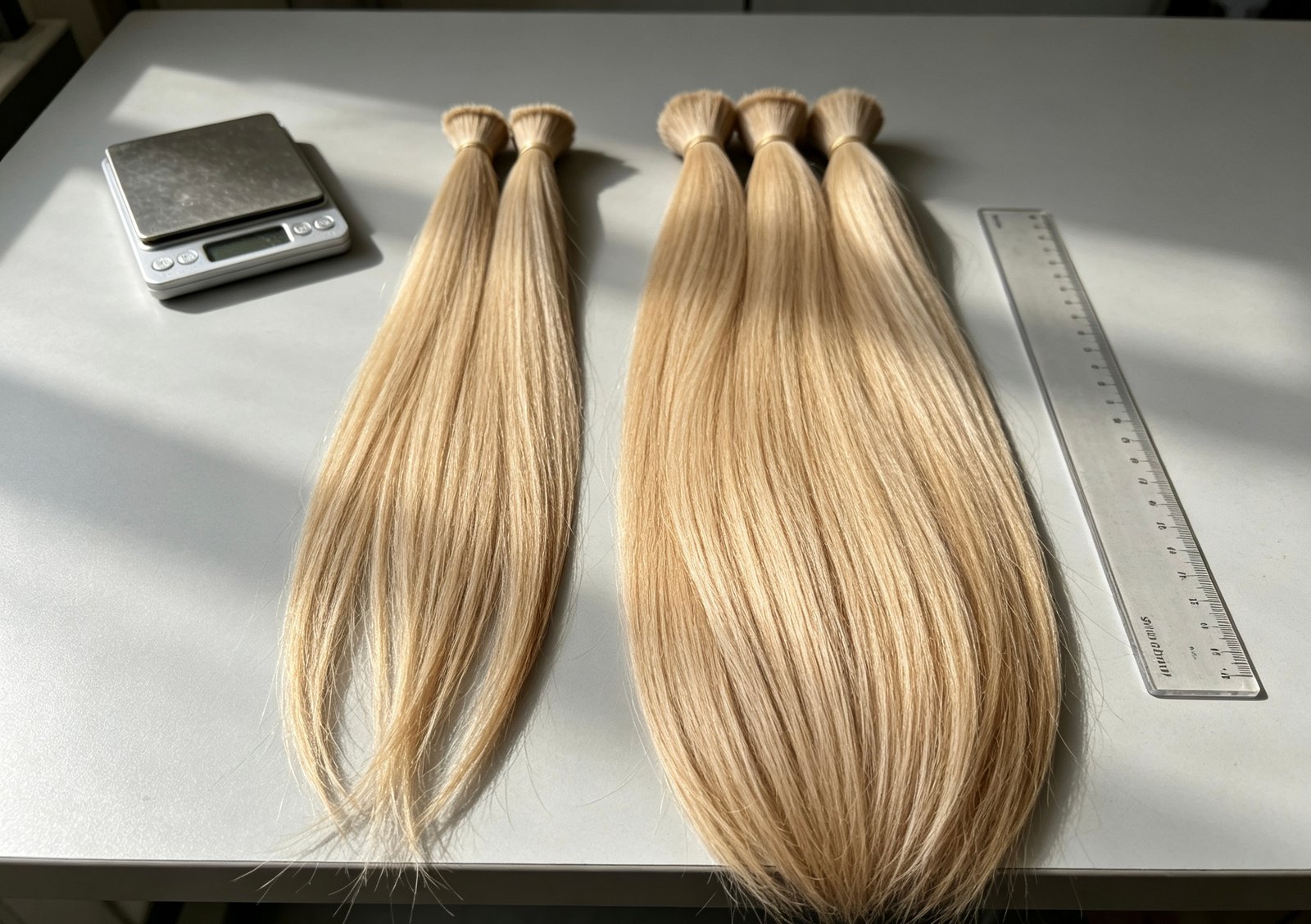 Illustrative side-by-side hair bundles with tapered and fuller ends for single and double drawn comparison