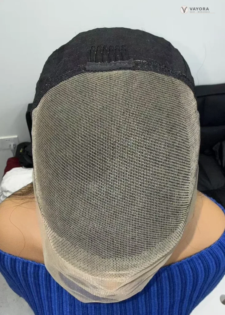 Front view of a glueless wig cap showing lace mesh and an internal comb.