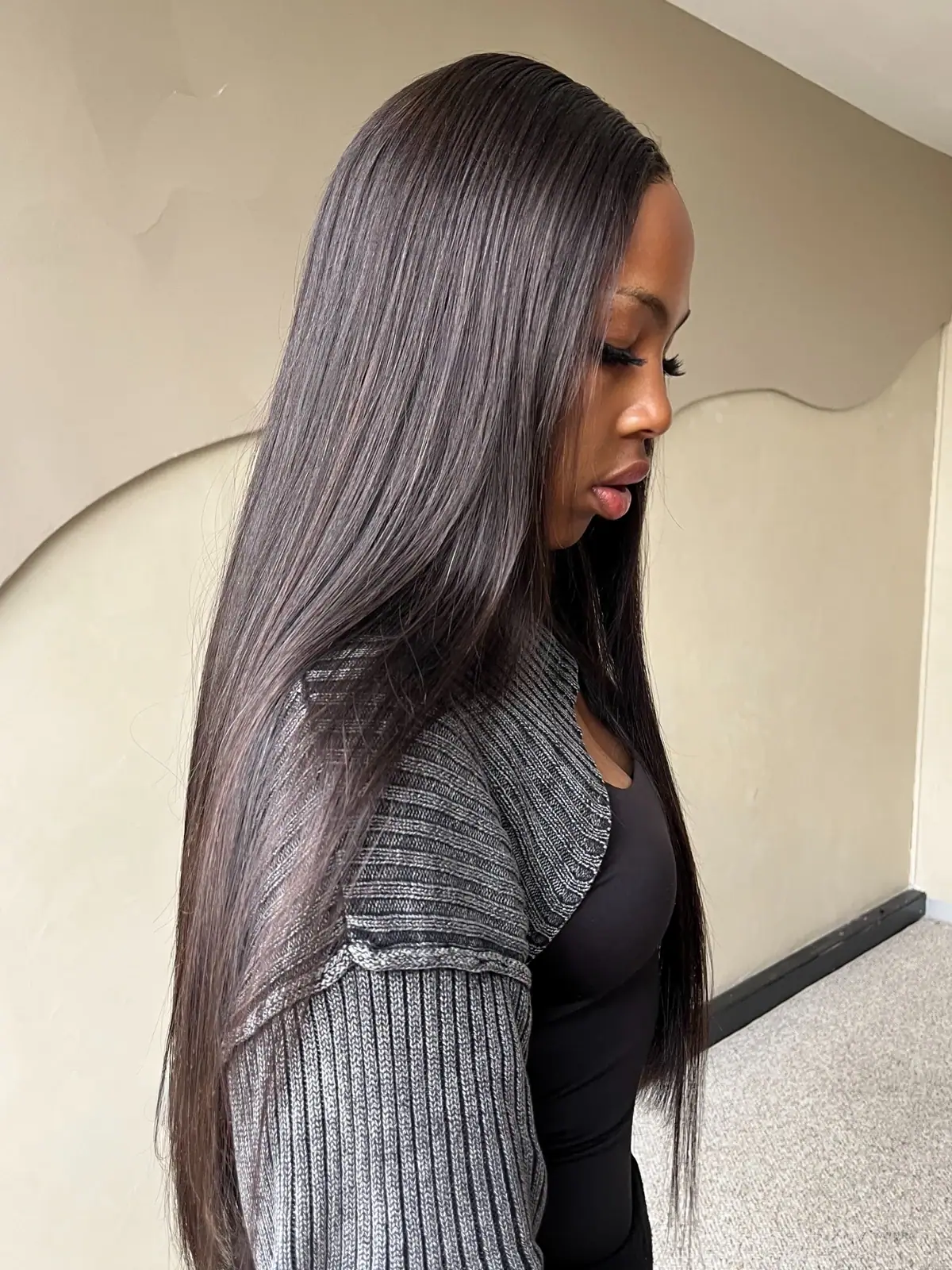Model with long dark straight hair, shown in profile