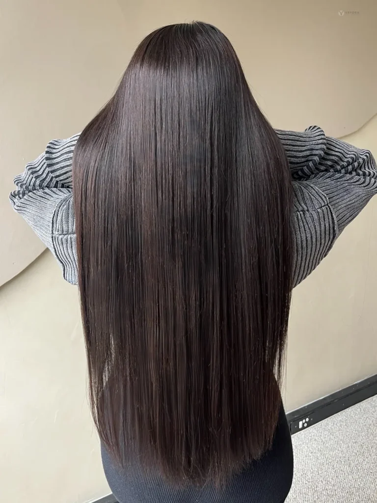 Model with long straight dark hair and a grey outfit