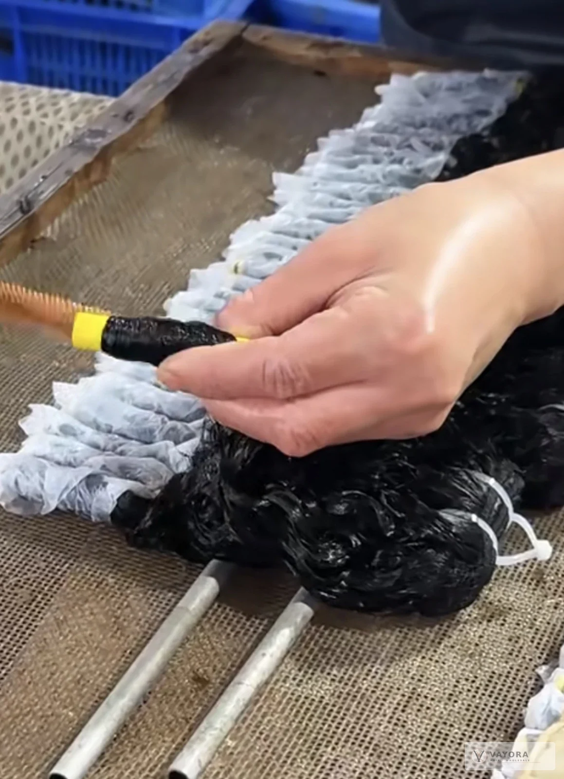 Hair wrapped around a rod during processing at VAYORA’s Xuchang manufacturing partner facility.