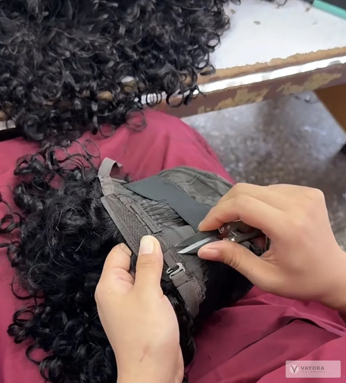 Thread trimming around a wig cap at VAYORA’s Xuchang manufacturing partner facility.