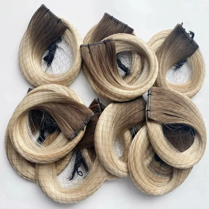 Rooted blonde human hair weft extensions with dark-to-light color transitions