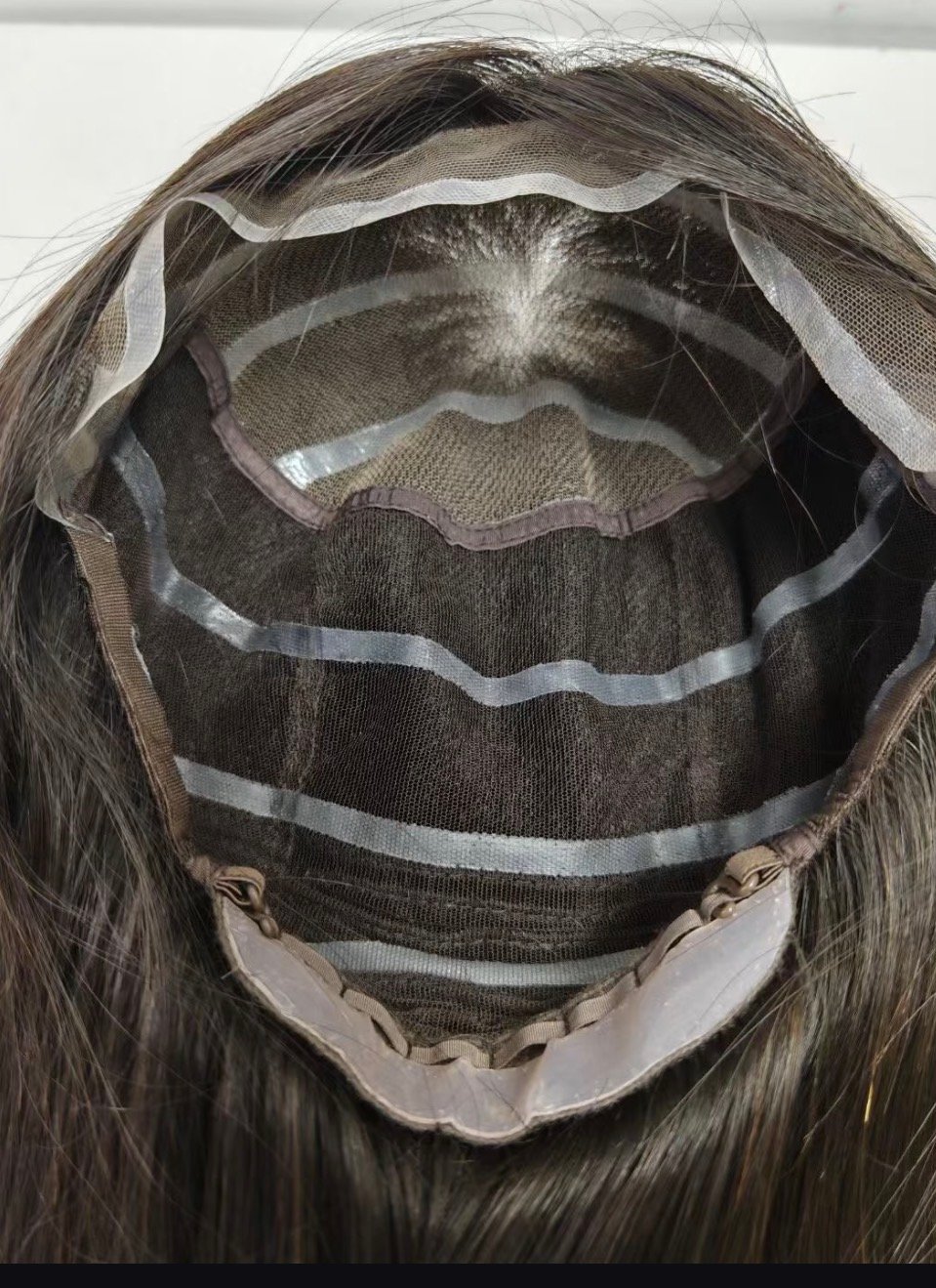 Interior view of a wig cap showing lace, mesh, seams and rear adjustment straps