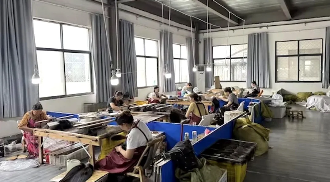 Workers handling hair materials at workstations in VAYORA’s Xuchang manufacturing partner workshop.